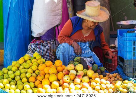 HUARAZ, PERU - JULY 27: Traditionally dressed peruvian people sell fruits and vegetables on the street market on July 27, 2017 in Huaraz, Peru.