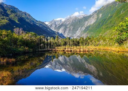 Franz Josef Glacier Reflecting In A Lake, New Zealand