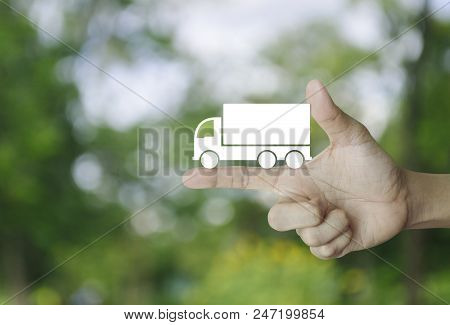 Truck Flat Icon On Finger Over Blur Green Tree Background, Business Transportation Service Concept
