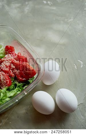 Delicious, Simple And Nutritious Meal. Fresh Tomato Salad, And Boiled Eggs. On A Gray Background Und