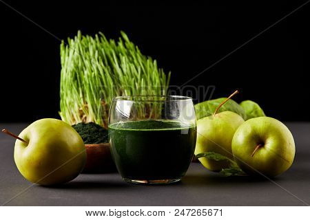 Fresh Smoothie From Spirulina, Apples, Leaves, Spirulina Powder And Spirulina Grass On Black Backgro