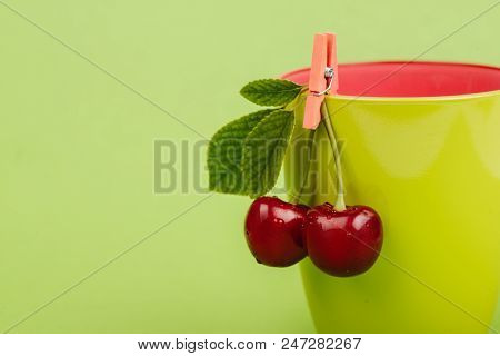 Fresh Cherries With Green Glass On Green Background