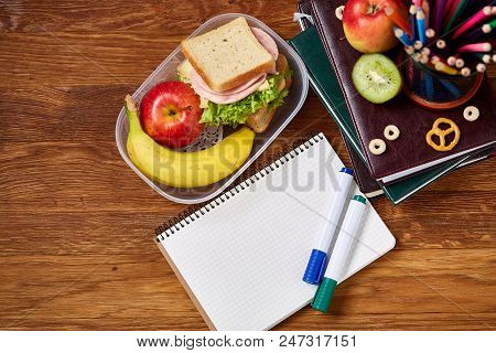 Concept Of School Lunch Break With Healthy Lunch Box Full Of Sandwiches, Banana, Apples And School S