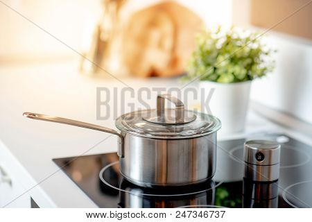 Stainless Steel Pot On Electric Stove With Kitchen Timer In Modern Kitchen. Cooking Utensils Concept