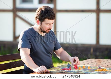 Man Playing Sythe Strategy Board Game Alone: Robots And Heroes Miniatures At The Boardgame Field, Cl
