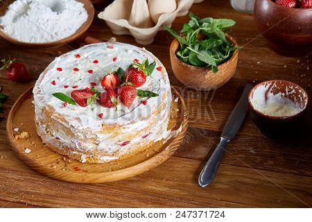 Strawberry Tart Covered With Whipped Sour Cream Surrounded By Organic Ingredients Over Wooden Backgr