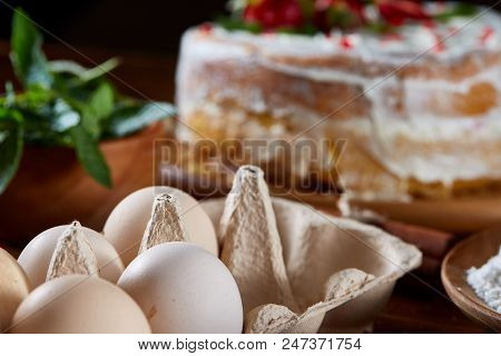 Strawberry Tart Covered With Whipped Sour Cream Surrounded By Organic Ingredients Over Wooden Backgr