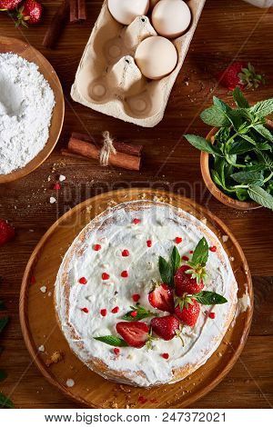 Strawberry Tart Covered With Whipped Sour Cream Surrounded By Organic Ingredients Over Wooden Backgr
