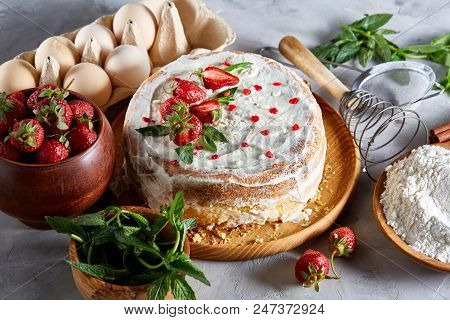 Strawberry Tart Covered With Whipped Sour Cream Surrounded By Organic Ingredients Over White Backgro