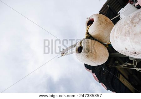 Close Up And Lower Angle Image Group Of Dirty White Fish Net Buoy Tied With Rope, Hanging Under Wood