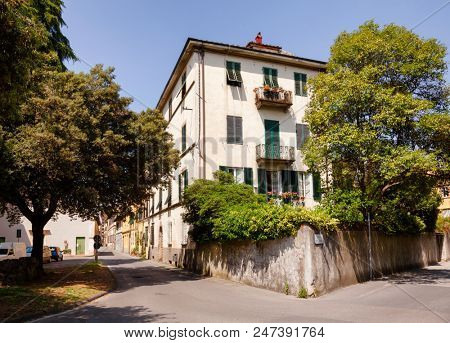 Typical mediterranean house with walled garden on narrow street of Lucca old town, Tuscany, Italy