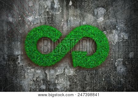 Eco And Circular Economy Concept. The Green Grass In Form Of Arrow Infinity Recycling Symbol On Dirt