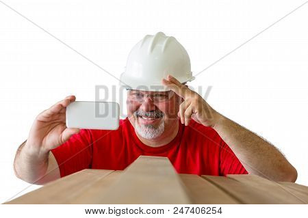 Smiling Happy Lumberman In A Hardhat And Safety Goggles Taking A Selfie At Work Gesturing With His H