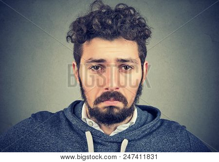 Closeup Of Young Hipster Man With Curls Having Depression And Looking Sadly At Camera With Pity.