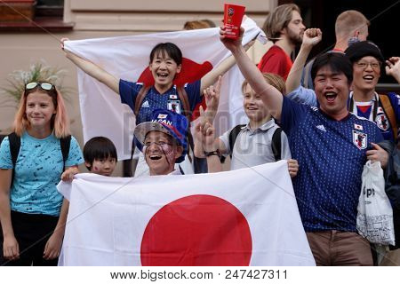 ST. PETERSBURG, RUSSIA - JUNE 28, 2018: Japanese football fans at FIFA Fan Fest celebrate qualifying their national team to knockout stage of FIFA World Cup 2018. Japan become 2nd in Group H