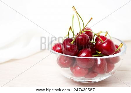 Healthy Eating And Food Concept - Cherries In Glass Dish. Cherry On Wood And White Background.