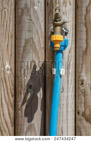 Summer Water Hosepipe Ban. Permanent Outdoor Brass Tap Switched Off. Water Tap On Wooden Fence With 