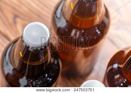 Close Up High Angle View Of Unlabelled Bottles Of Craft Beer With Focus To The Cap On A Single Bottl