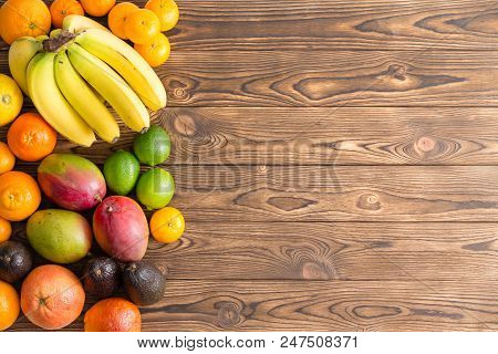 Colorful Border Of Assorted Fresh Tropical Fruit With Bananas, Mango, Orange, Lemon, Lime, Avocado P