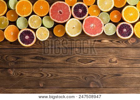 Top Border Of Colorful Cut Ripe Citrus Fruits With Oranges, Grapefruit, Lemon, Lime, Clementines And