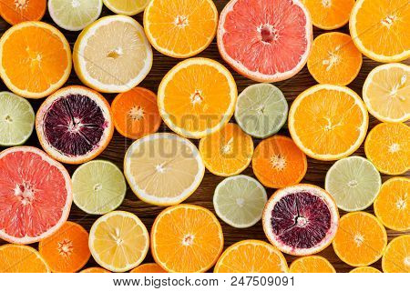 Background Texture And Pattern Of Mixed Ripe Healthy Juicy Cut Citrus Fruit Sliced In Halves In A Co