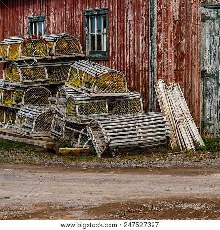 Lobstering Equipment Stacked Against A Weathered Shed In The Fishing Village Of Rustico , Prince Edw