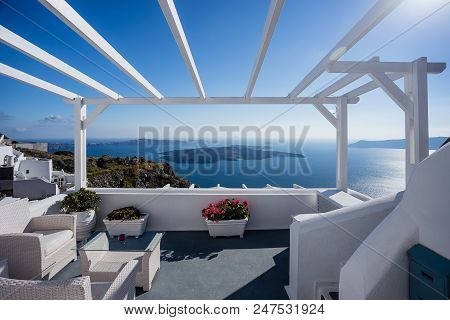 Gourgeous Balcony View In White Walled Resort In Santorini, Greece, With Ocean And Cliffs In The Bac