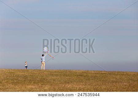Kaseberga, Sweden - June 26, 2018: An Adult Man Helping A Little Child Flying A Kit.