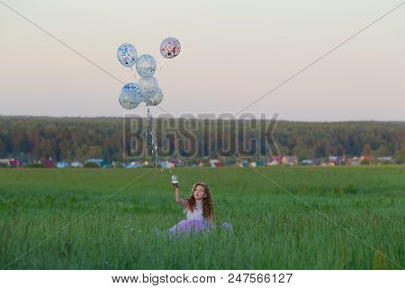 Little Girl With Balloons On A Walk In The Field