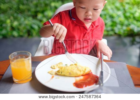 Cute Little Asian 2 Years Old Toddler Baby Boy Child Wearing Red Shirt Use Fork And Knife Eating Bre