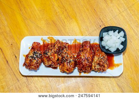 Spicy Korean Chicken Wings In White Plate On Wooden Table