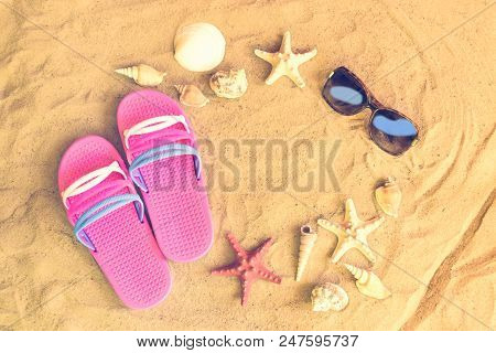 Pink Flip Fops, Sunglasses, Starfishes And Seashells On Sand Beach