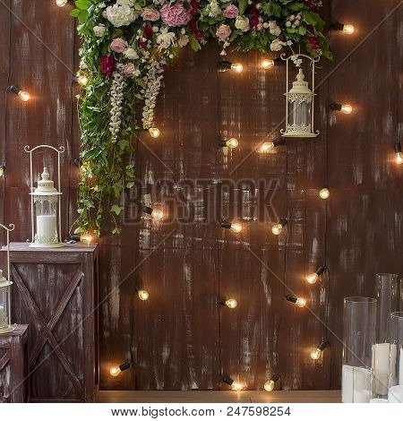 White Lantern On Browm Wooden Background Or Fence With Flowers Decoration.