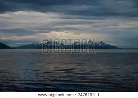Sea In Hammerfest, Norway. Evening Seascape With Mountain Coast Under Cloudy Sky. Sea Travelling. Ad