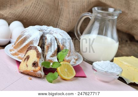 Sliced Homemade Lemon Bundt Cake Sprinkled With Sugar, Milk, Eggs, Melissa Leaves, And Butter, Still