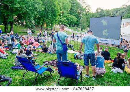 Lviv, Ukraine - June 1, 2018: People Sitting On Grass In City Park Watching Movie In Open Air Cinema