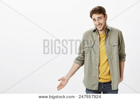 So Waht. Portrait Of Careless Handsome Bearded Guy With Curly Hair, Gesturing With Palm And Shruggin