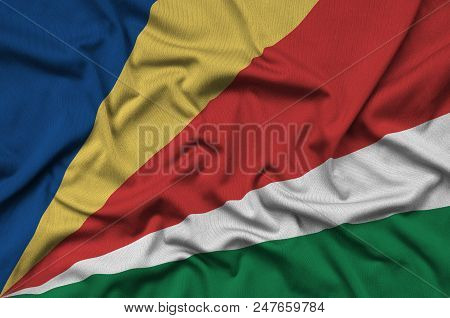 Seychelles Flag  Is Depicted On A Sports Cloth Fabric With Many Folds. Sport Team Waving Banner