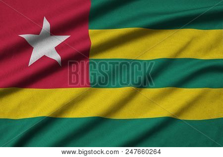 Togo Flag  Is Depicted On A Sports Cloth Fabric With Many Folds. Sport Team Waving Banner