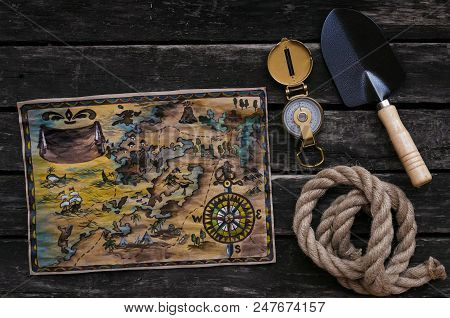 Treasure Map, Compass, Shovel And Rope On Old Wooden Table Background. Treasure Hunter Concept.