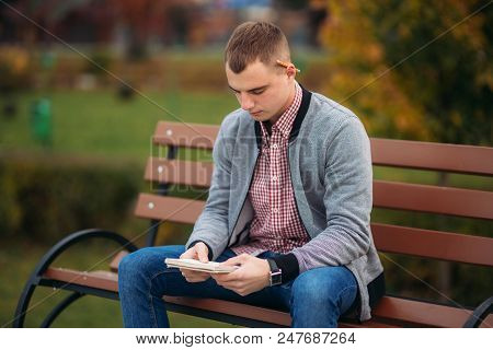 A Cute Student Writes Down His Thoughts In His Notebool Using A Pensil.