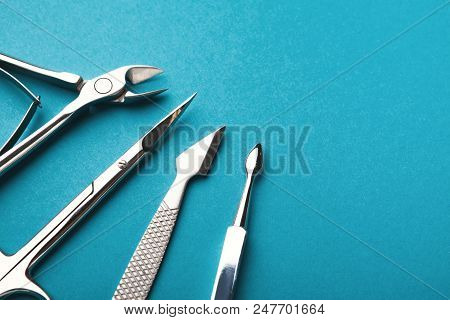 Manicure And Pedicure Beauty Accessories On Blue Background, Copy Space. Cutice Cutter And Pushers, 