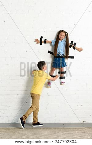 Brother Gluing Sister To Wall With Black Tape At Home