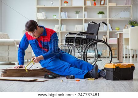 Disabled man laying floor laminate in office