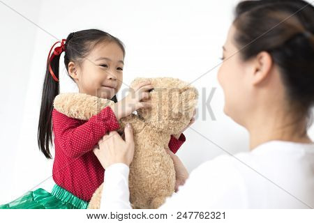 Attractive Asian Girl Received A Doll In Brithday From Her Mom. Kid Holding Bear Doll With Attractiv