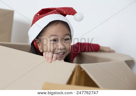 Asian Girl Playing In The Box At Home. Kid Sitting Inside Box With Attractive Smiling.