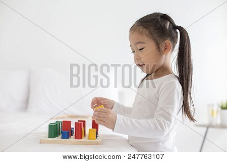 Girl Playing Toy With Attractive Smiling At Home. Happy Family Concept.