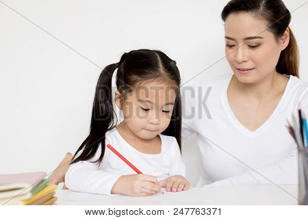 Attractive Little Girl Writing Book. Mom Teaching Her At Home. Children Lifestyle, Education Concept