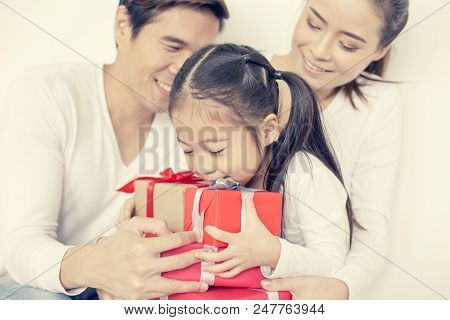 Attractive Asian Family Holding With Each Other. Kid Received Gift With Attractive Smiling. Kid With