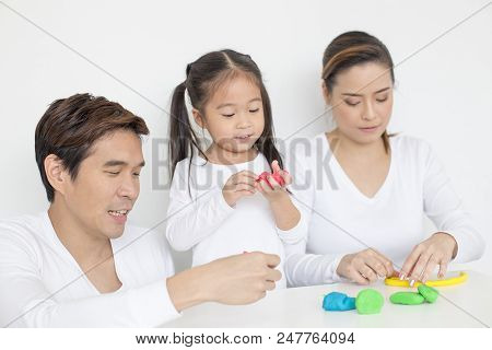 People Playing Toy With Kid At Home Together. Happy Family Concept.